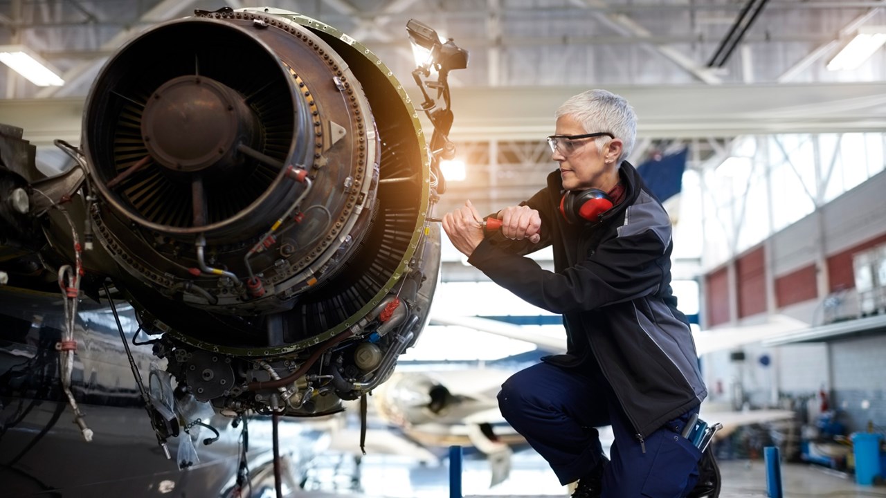 Photo of woman engineer fixing aircraft engine