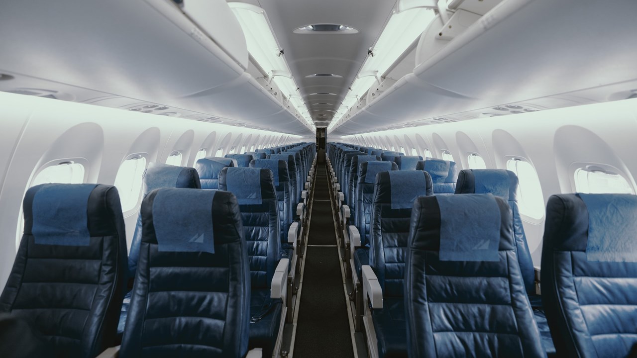 Photo showing interior of a plane with empty seats