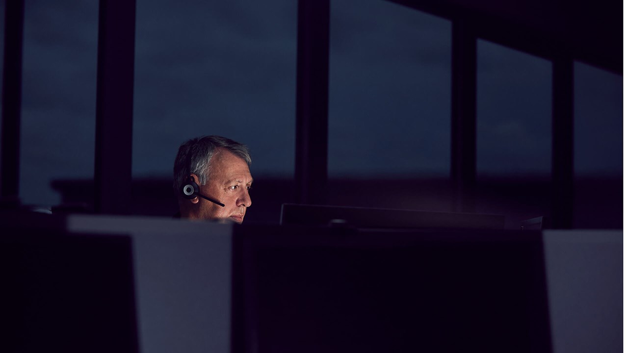 Male employee in a dark room in front of a computer