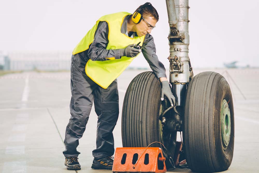 A mechanic checks aircraft landing wheels