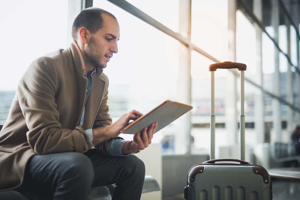 A male passenger checks his table tin the airport