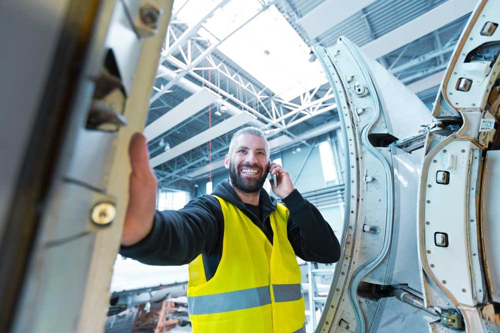 Mechanic smiling while on the phone